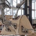 Vier Robotarme nehmen im Gleichtakt Holzplatten auf und platzieren sie gemäss Computerentwurf im Raum. (Bild: Pascal Bach / Gramazio Kohler Research, ETH Zürich)
